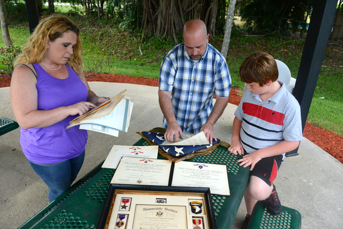 Meghan Burns, Jeremy Teitler and Conner Burns looking through the items that they found in their attic at Veteran's Park in Coral Springs 