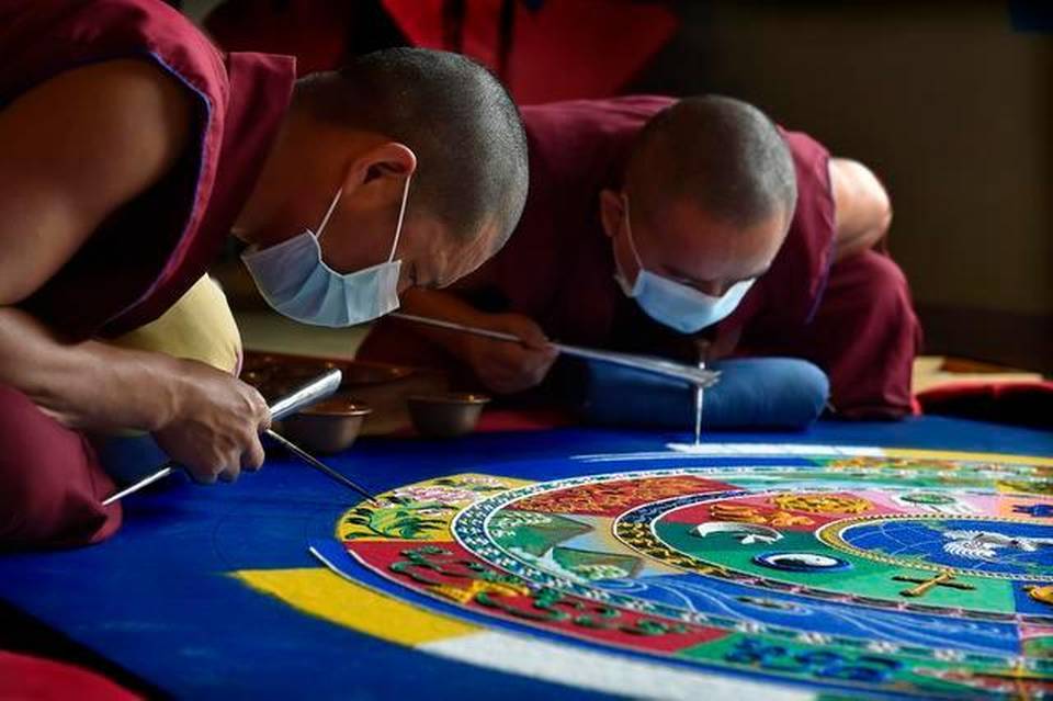 Tibetan monks from the Drepung Gomang Monastery in India building a sand mandala.