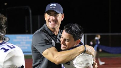 Head Coach Matt Garris embraces with wide receiver Collin Teschky. {CSC Athletics}